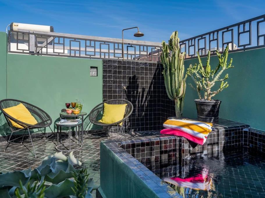 a patio with a table and chairs and a swimming pool at Riad Secret Garden Hideaway (privative) in Marrakesh