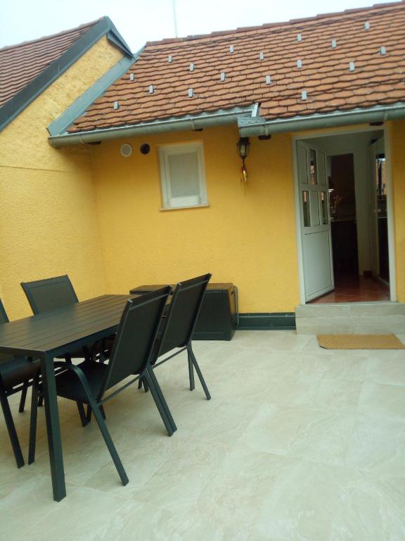 uma mesa e cadeiras em frente a uma casa amarela em VERICA em Samobor