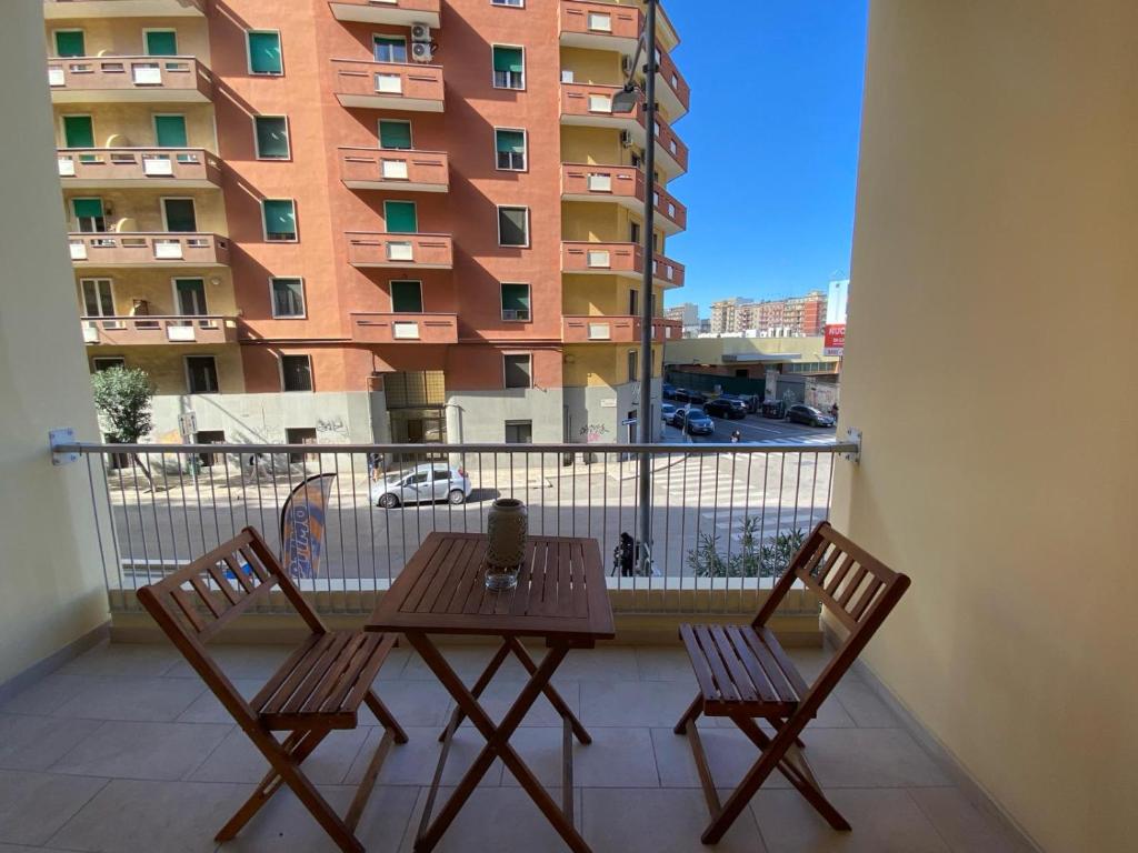 uma mesa e cadeiras numa varanda com um edifício em Ennio Rooms em Bari