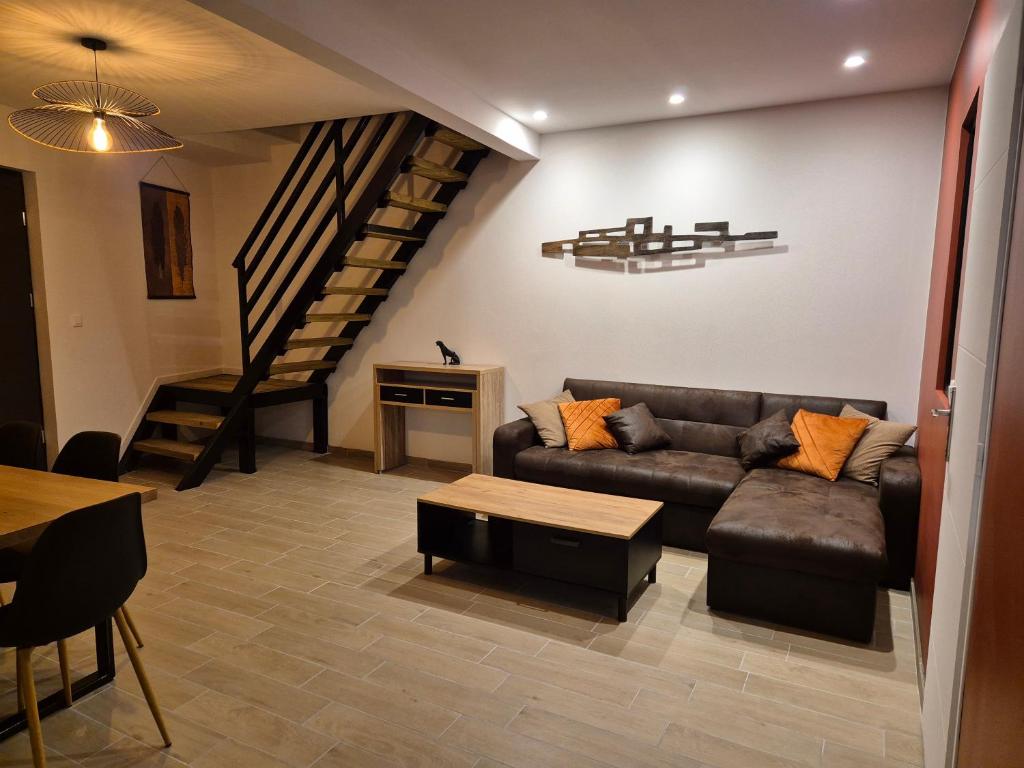 a living room with a couch and a staircase at Au Beau Regard in Belleu