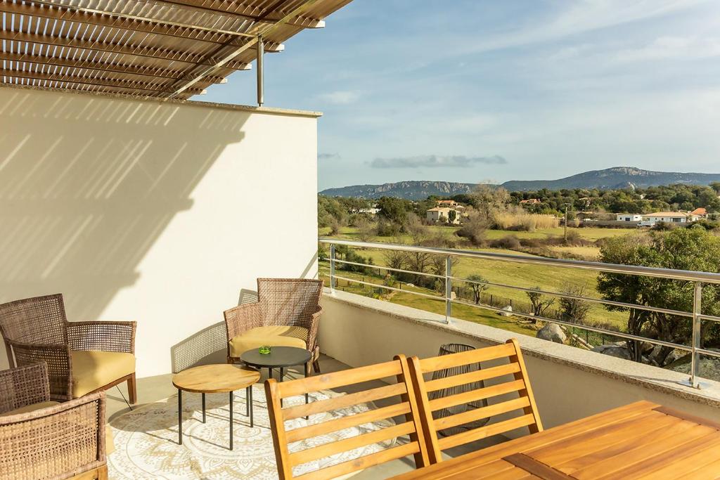 un balcon avec une table et des chaises et une vue dans l'établissement Flaubert 25 - Domaine d'Arca - 4 pers, à Porto-Vecchio