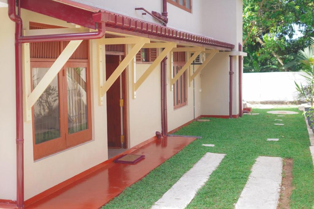 einen seitlichen Blick auf ein Haus mit grünem Rasen in der Unterkunft A & N Anchorage Rented Home 60 sq m Approved by Sri Lanka Tourism Development Authority in Nawala