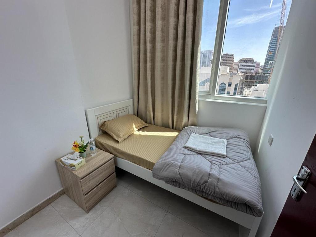 małe łóżko w małym pokoju z oknem w obiekcie Corniche AD - Stunning Room w Abu Zabi