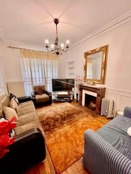 un salon avec un canapé et une cheminée dans l'établissement Beau 3P en plein cœur du 15eme Proche de Beaugrenelle et de la Tour Eiffel. ., à Paris