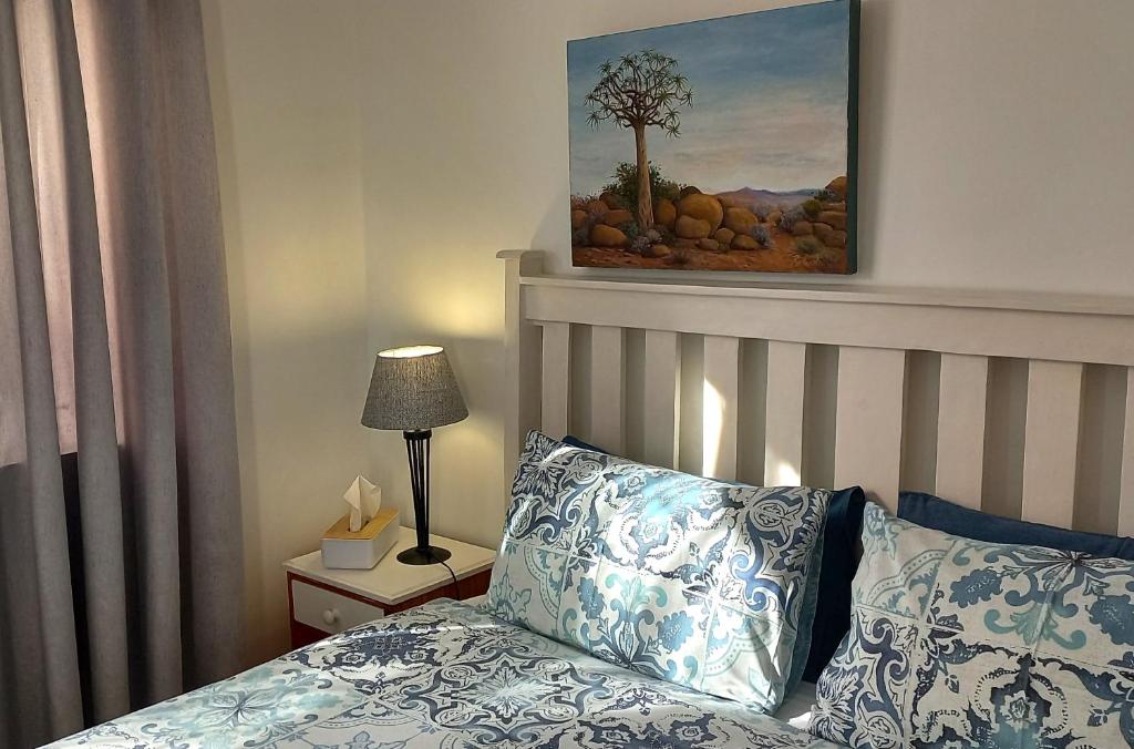 Durbanville的住宿－19 on Robyn，卧室配有一张床,墙上挂有绘画作品