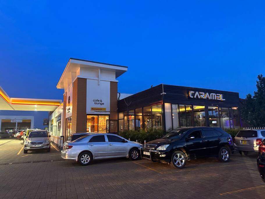 a parking lot with cars parked in front of a store at Vera's Luxury Home in Munyonyo