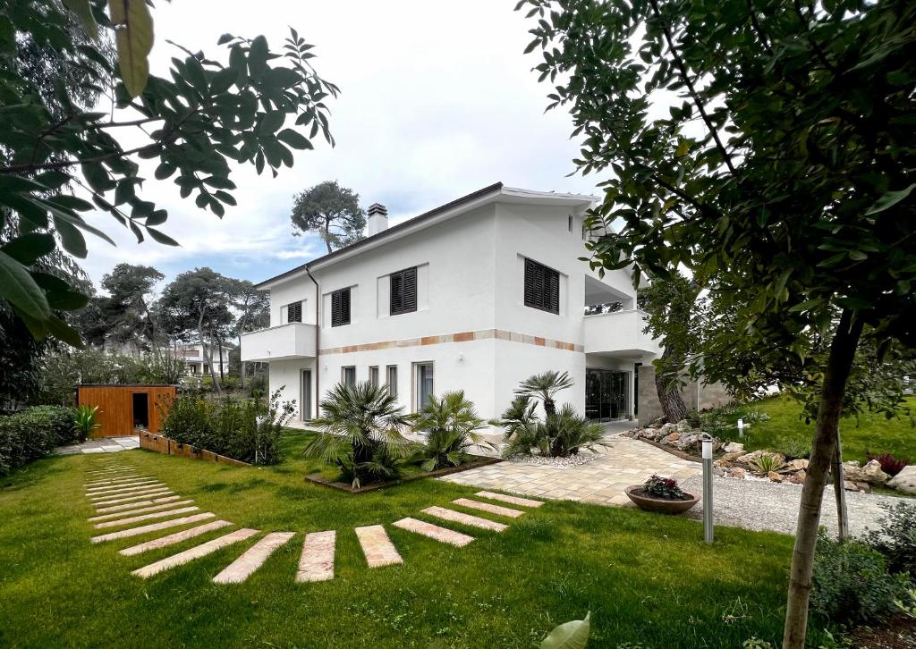 a white house with a grassy yard at Pinea b&b in Castellaneta Marina 