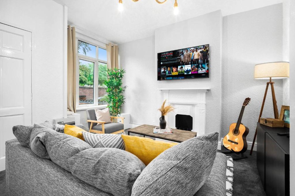 a living room with a couch and a guitar at Beautiful 3 Bed House Close to City Centre - Top Rated - Netflix - WIFI - Smart TV - 17ML in Birmingham