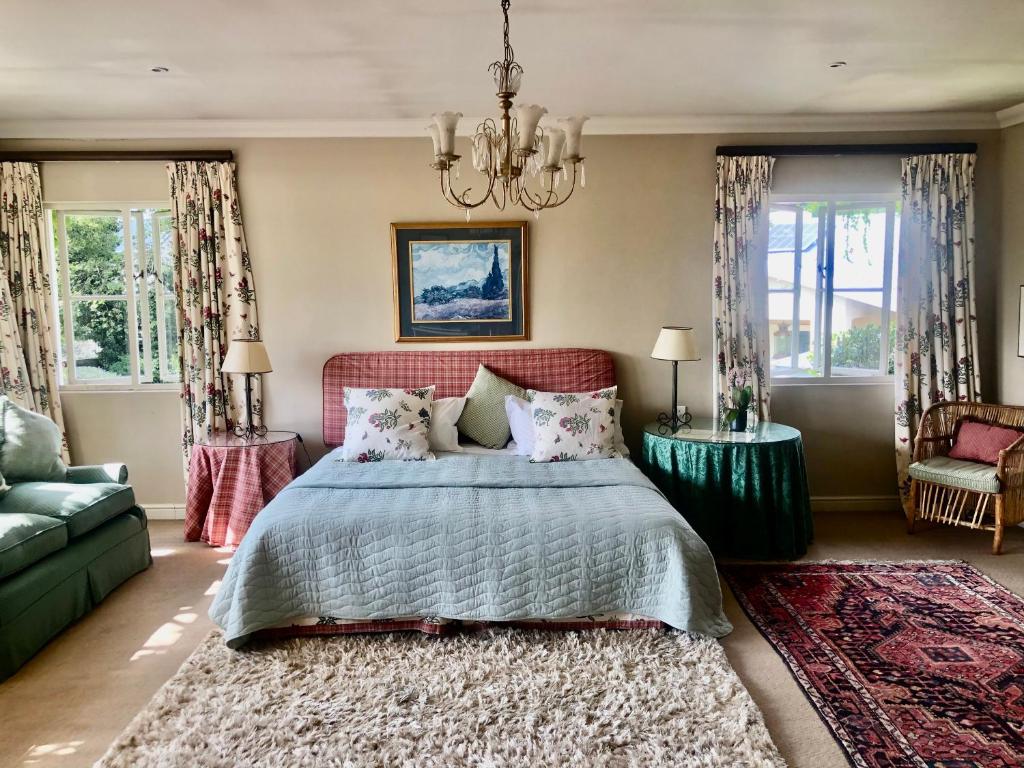 1 dormitorio con cama, sofá y ventanas en Grace on Argyle, full solar suite in Sandton, en Johannesburgo