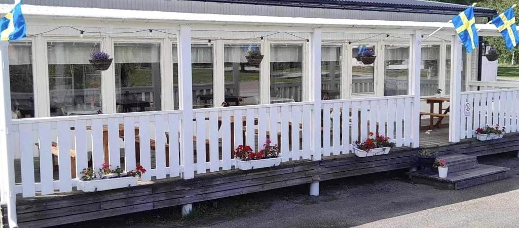 un bâtiment blanc avec des plantes en pot et des fleurs sur lui dans l'établissement Gullringens Värdshus & hotell, à Gullringen