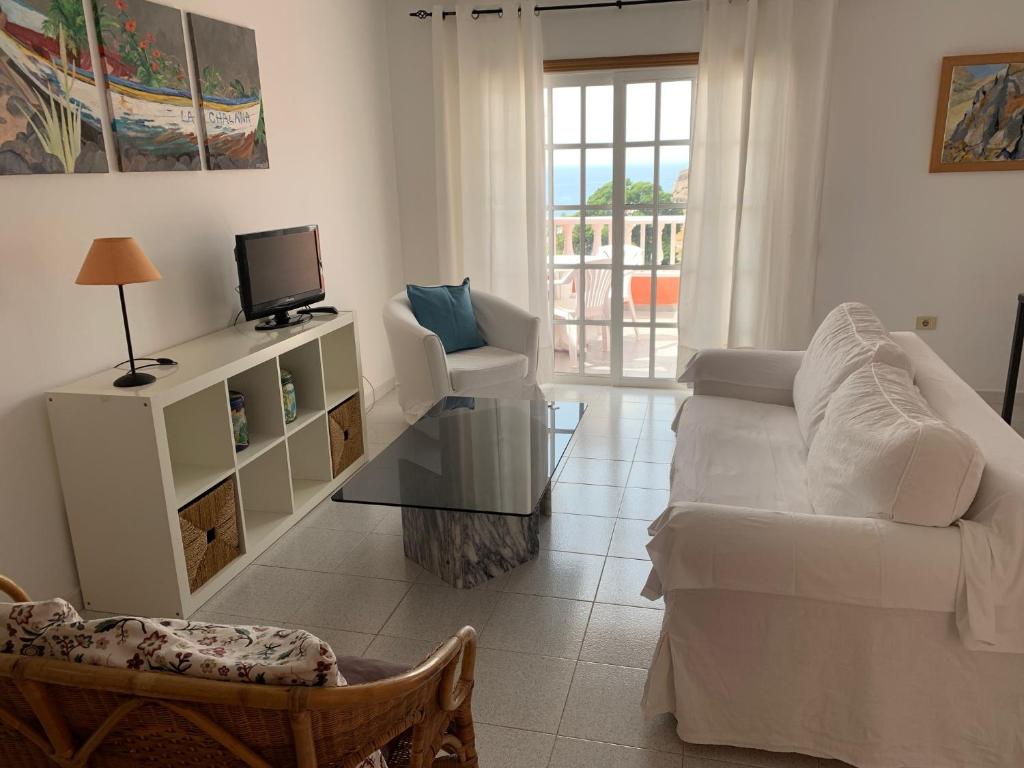 sala de estar con sofá blanco y TV en Apartamentos Bellavista Gomera en Playa de Santiago