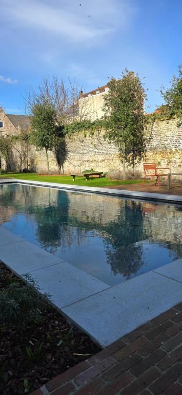 a swimming pool with a red bench in a park at B'Guest Sleep & Retreat in Bruges