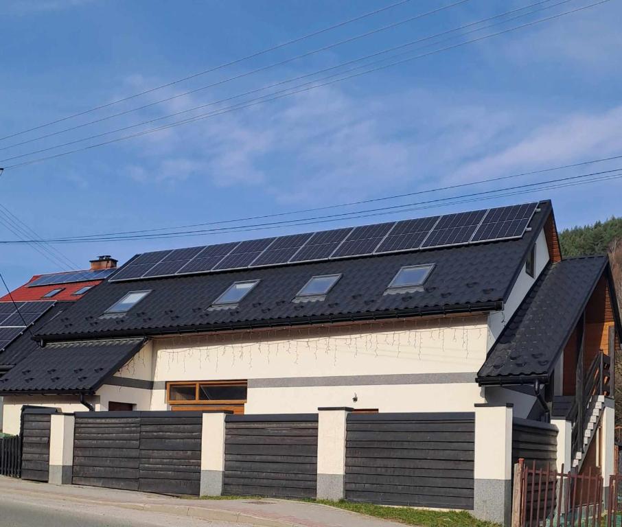 una casa con paneles solares en el techo en U Beaty, niezależne mieszkania do wynajęcia, en Ochotnica Górna
