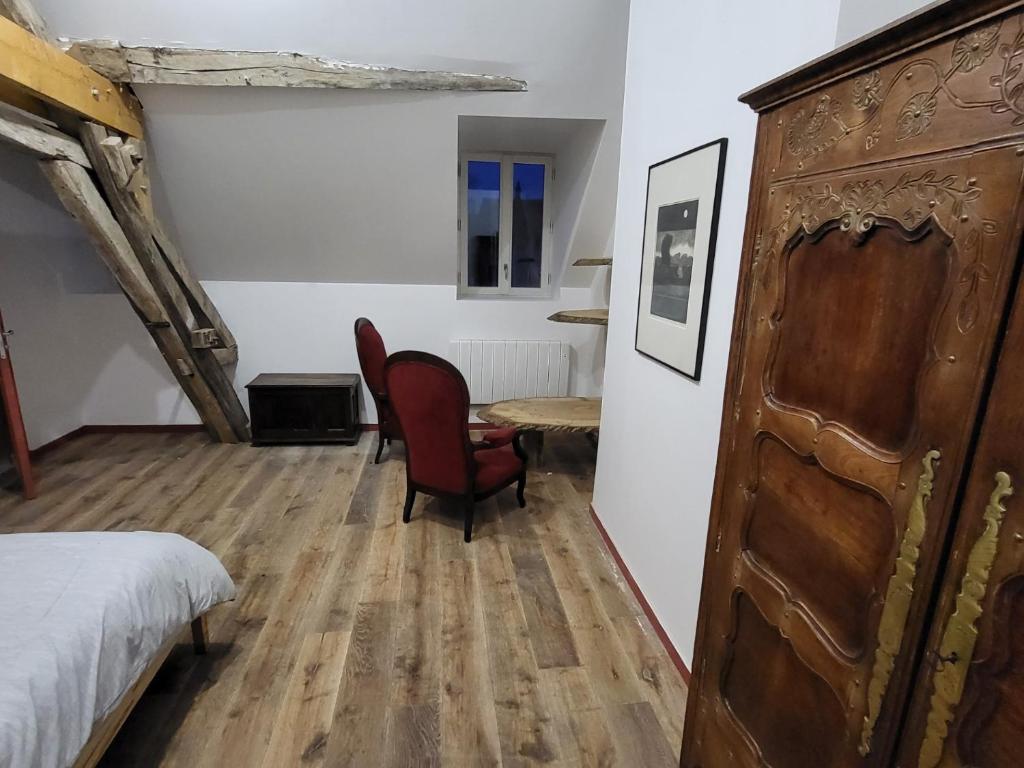 Escolives-Sainte-CamilleにあるLes Oiseaux de Passageのベッドルーム1室(ベッド1台、テーブル、椅子付)