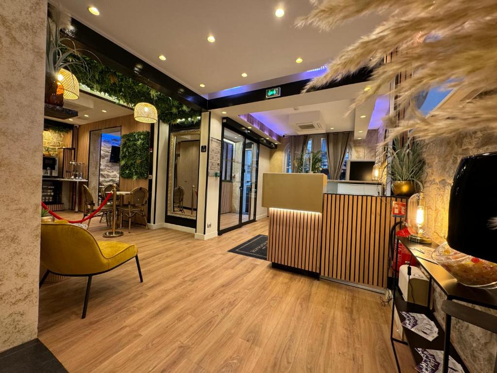 eine Lobby mit einem gelben Stuhl und einem Tisch in der Unterkunft Hotel Nation Montmartre in Paris