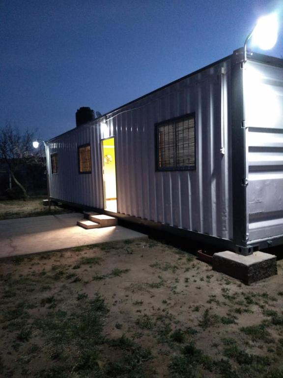 un pequeño edificio de metal con la puerta abierta en container en San Gerónimo