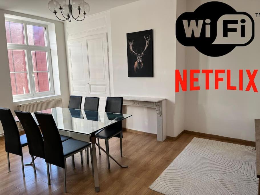 une salle à manger avec une table en verre et des chaises noires dans l'établissement Grand Duplex* proche Gare*Centre*spacieux, à Dunkerque