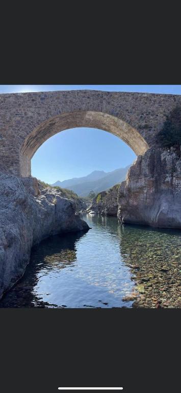 un pont en pierre sur une masse d'eau dans l'établissement Maison de village, à Manso
