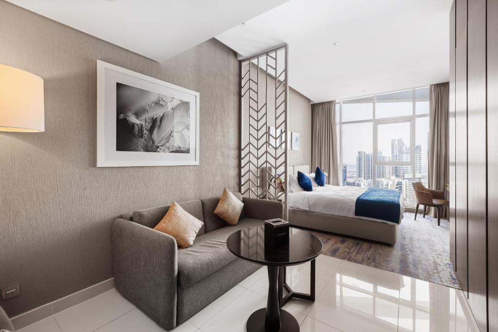 une chambre d'hôtel avec un canapé et un lit dans l'établissement New Aparthotel Prive, à Dubaï