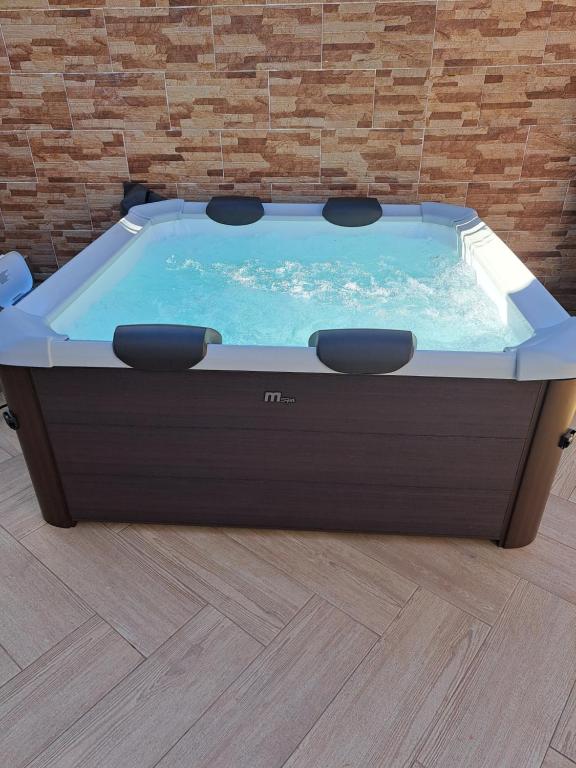 a jacuzzi tub in a room with a brick wall at Zurrinha holidays in Quarteira