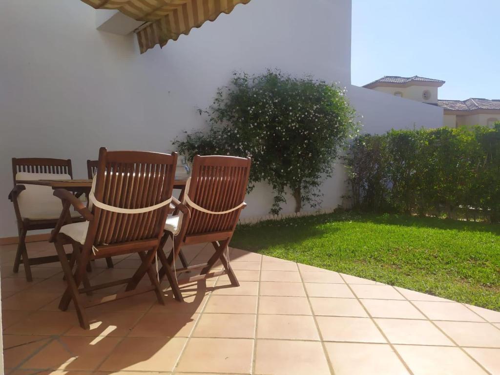 奇克拉納－德拉弗龍特拉的住宿－Villa Bosque Novo Sancti petri Grupo AC Gestión，庭院里设有两把椅子和一张桌子