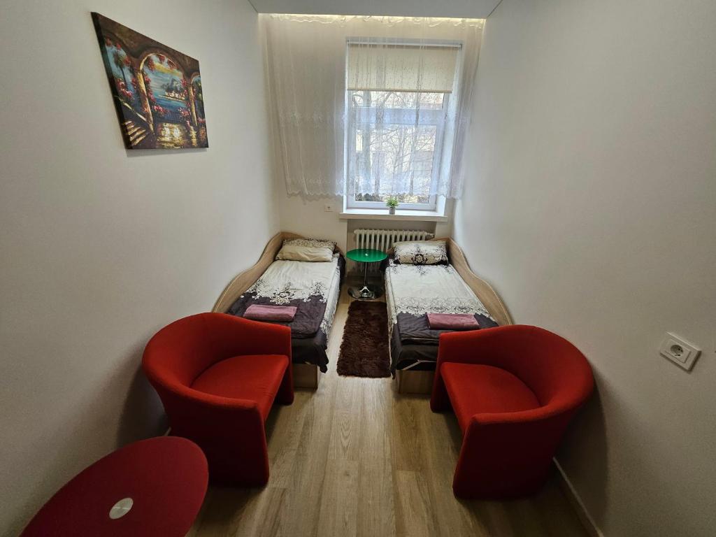 - une chambre avec 2 lits, 2 chaises et une fenêtre dans l'établissement Kambarys centre prie funikulieriaus #4, à Kaunas