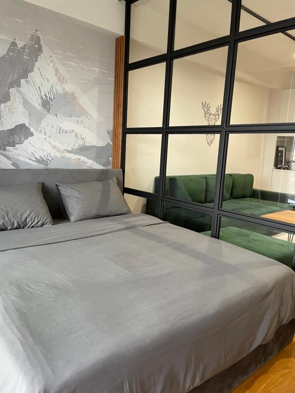 1 dormitorio con cama grande y ventana grande en Urban LEKS apartment, en Skopje
