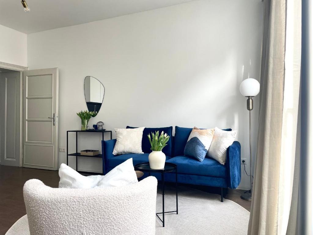 a living room with a blue couch and a chair at The blue VIEcation apartment in Vienna