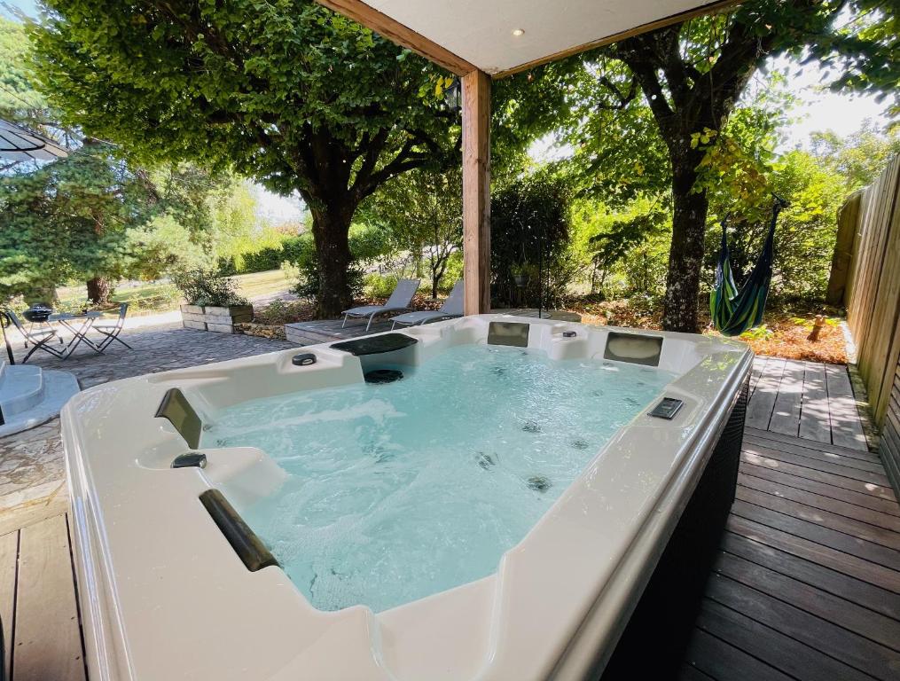 薩爾拉拉卡內達的住宿－Tournesol & Anémone Sarlat，树荫甲板上的按摩浴缸