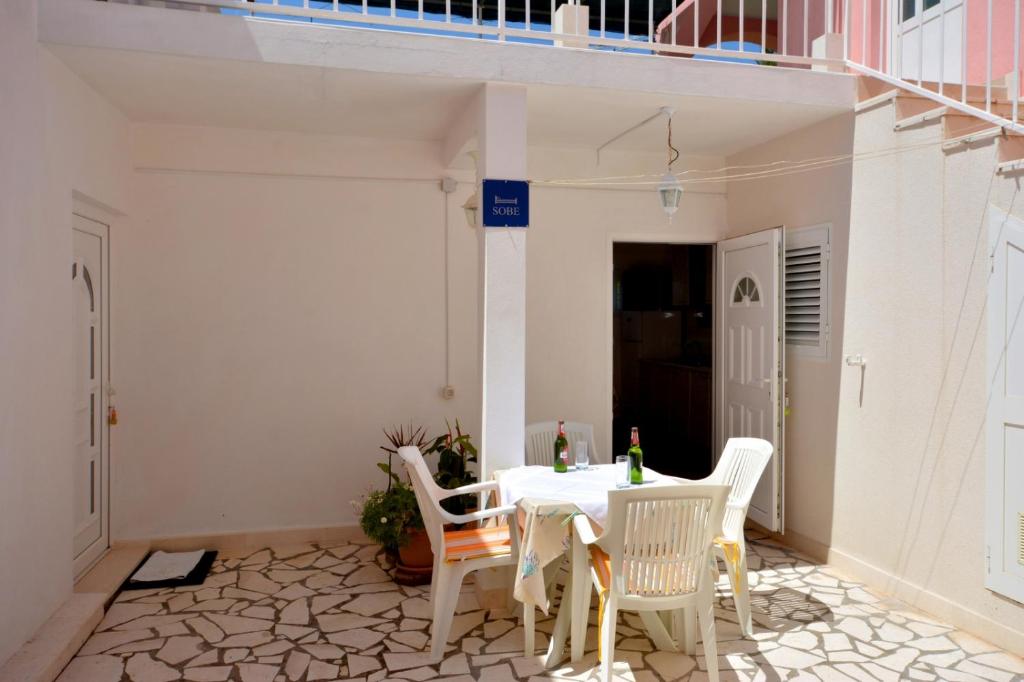 patio z białym stołem i krzesłami w obiekcie 2-bedroom apartment with seaview 3558-2 w mieście Žuljana