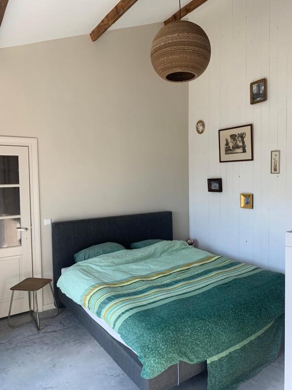 een slaapkamer met een bed met een groen dekbed bij B&B de Brem in Berkel-Enschot