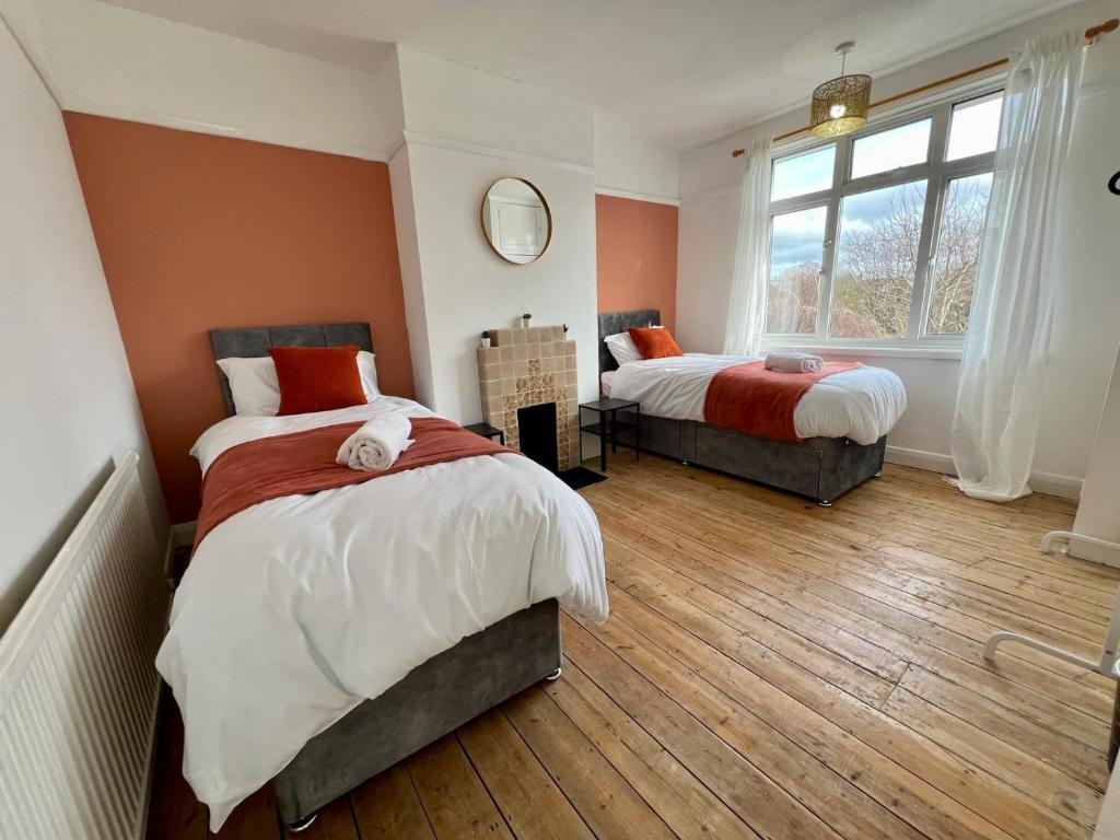 a bedroom with two beds and a window at Treasure Chest Chessington in Ewell