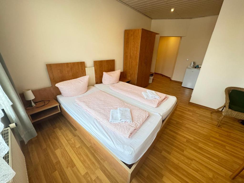 sypialnia z łóżkiem i dwoma ręcznikami na nim w obiekcie Pension Sonnenschein w mieście Halle (Saale)