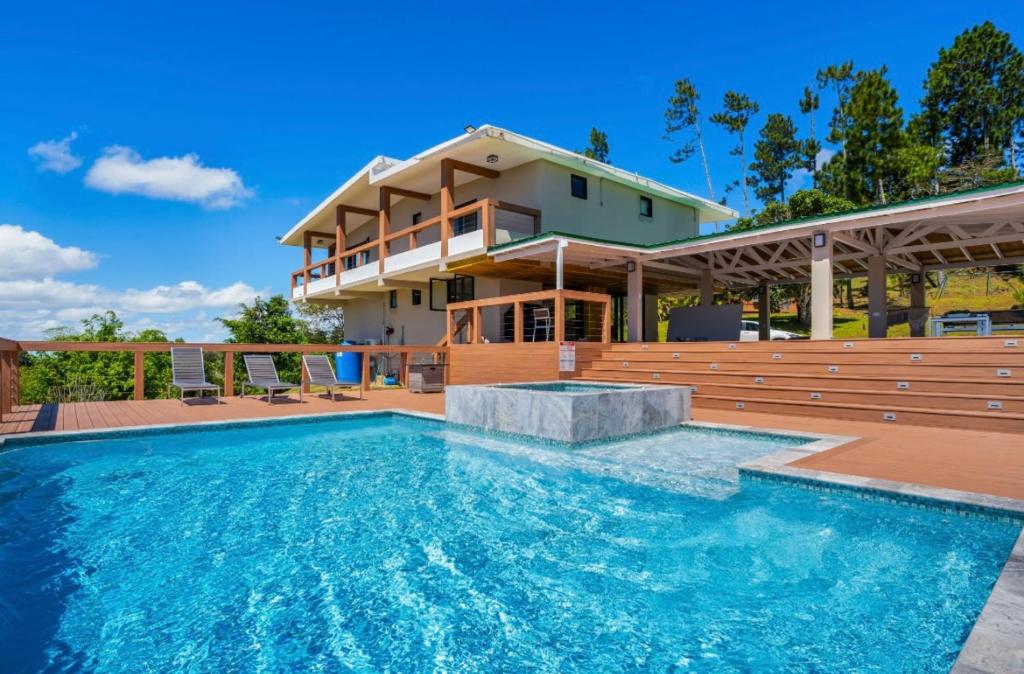 una casa con piscina frente a una casa en Rainforest Luxury Villa at El Yunque National Forrest, en Benitez