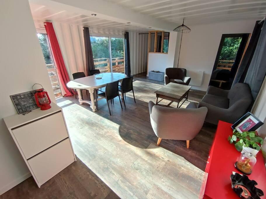 een woonkamer met een tafel en stoelen bij Gîtes de la Gare - Les conteneurs in Plessé