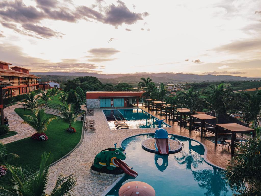 a resort with a swimming pool with tables and chairs at Escarpas resort in Capitólio