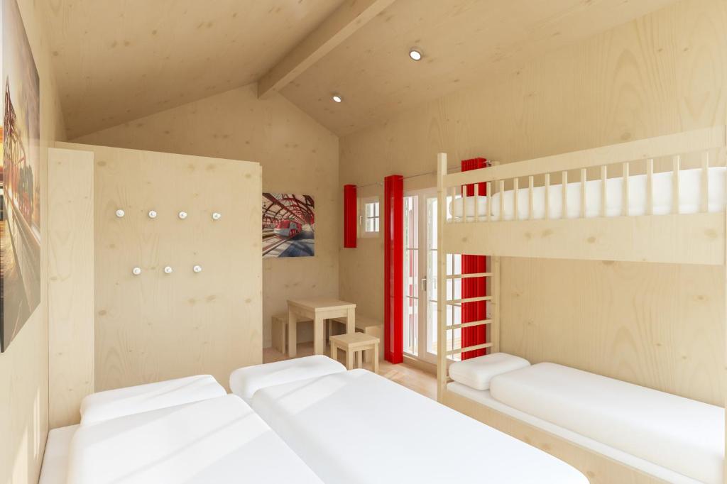 Zimmer mit 2 Etagenbetten und einer Leiter in der Unterkunft Ravensburger Spieleland Feriendorf in Meckenbeuren