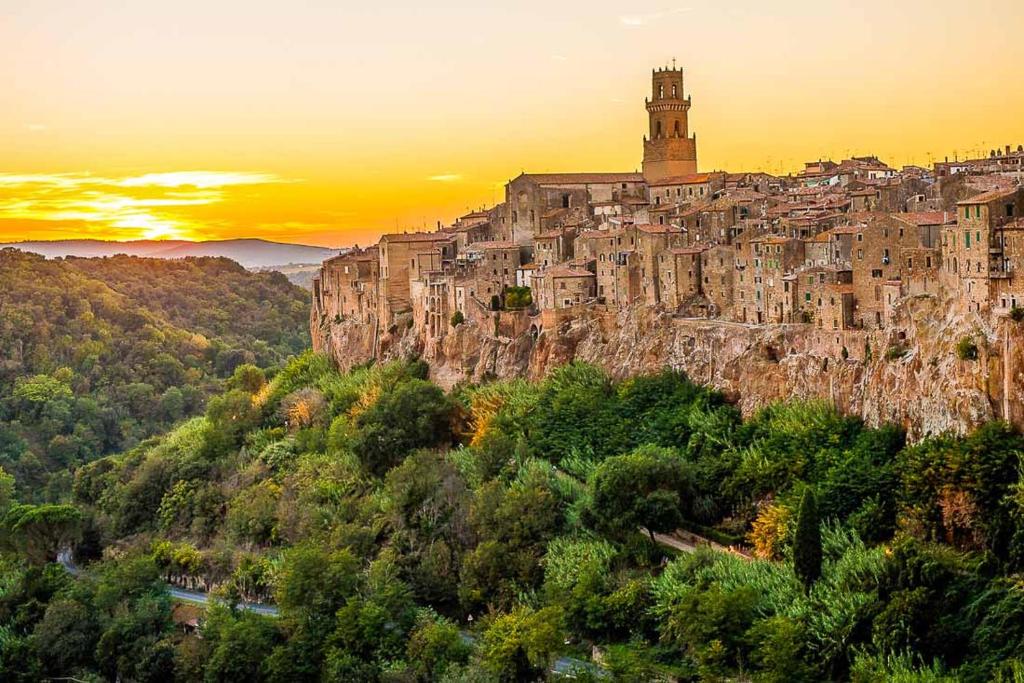 a town on top of a mountain at sunset at Dimora Montebello in Pitigliano