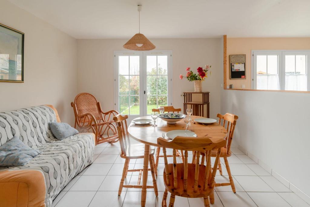 een woonkamer met een tafel en een bank bij Maison familiale avec jardin in Pornic
