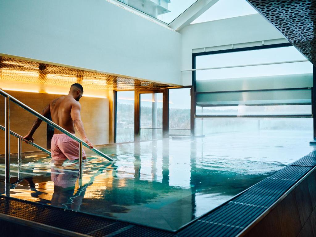 Ein Mann im Wasser im Schwimmbad. in der Unterkunft Clarion Hotel Stockholm in Stockholm