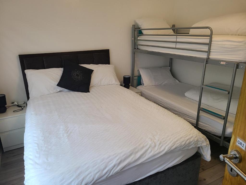 Ifield的住宿－QUICK STOP-GATWICK STAY, Family Room-GR1，一间卧室配有一张床和两张双层床。