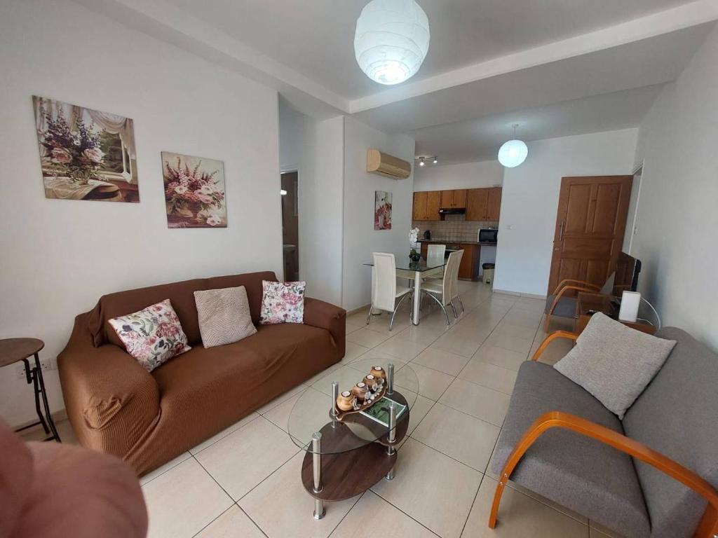 a living room with a couch and a table at Sunny 2 Bedroom Larnaca Center in Larnaka
