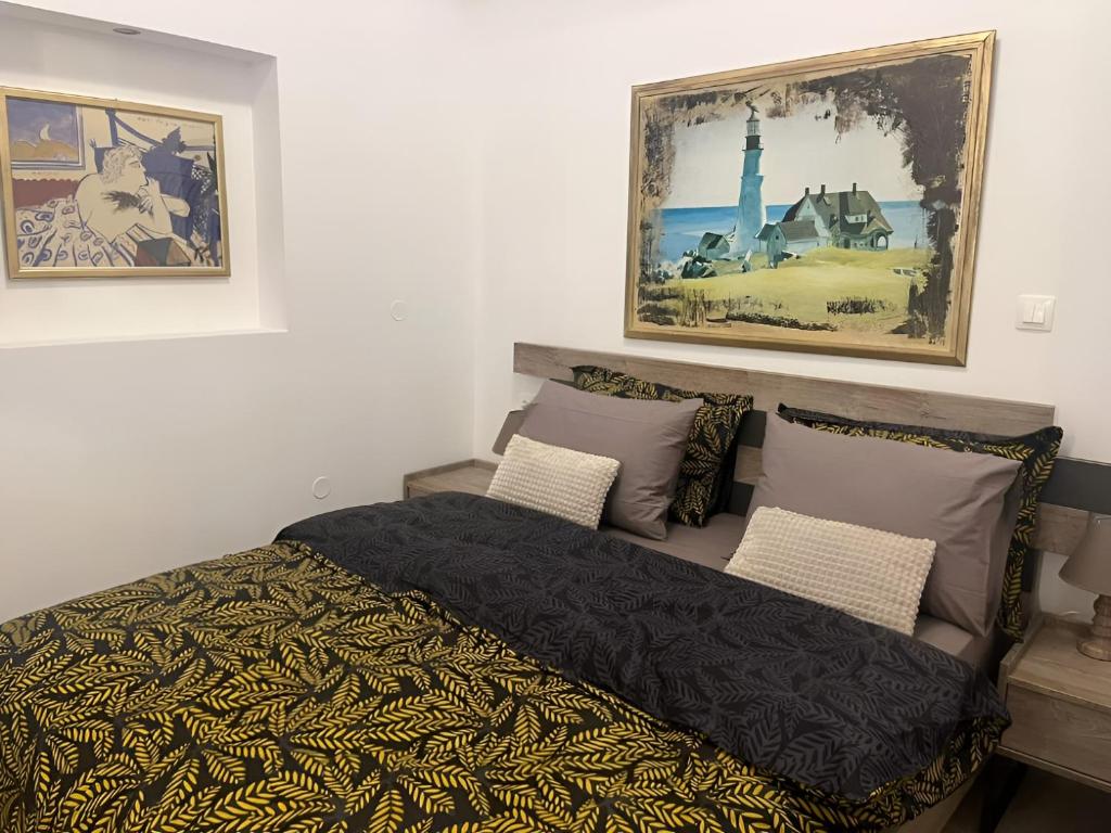 a bedroom with a bed and two pictures on the wall at La Maisonette, Florina Center in Florina