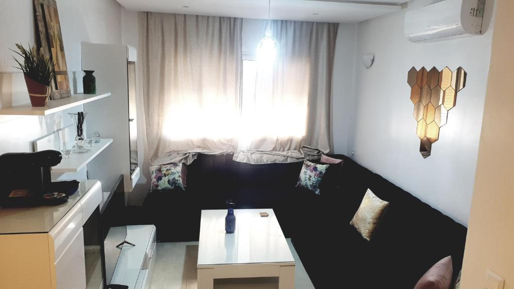 a small living room with a table and a window at Coralia Haut Standing Appart f2 in Oujda
