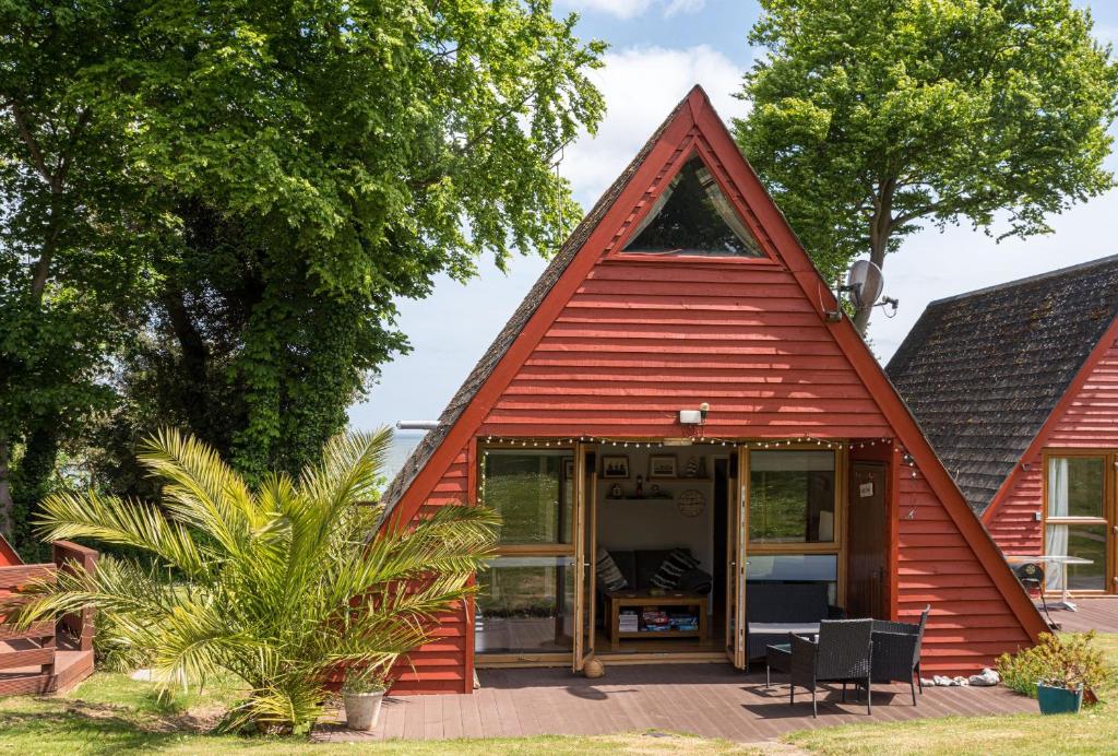 a small red house with a pitched roof at Chalet Thirteen in Deal