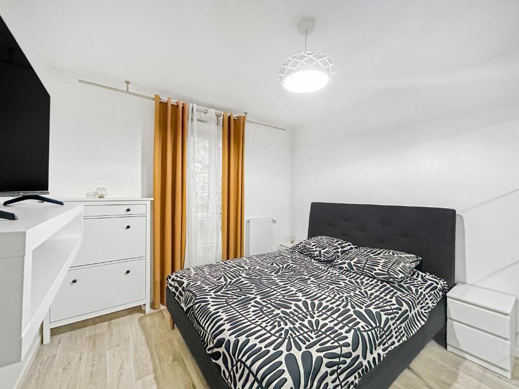 une chambre avec un lit avec une couette noire et blanche dans l'établissement Sérénité Urbaine Aubervilliers, à Aubervilliers