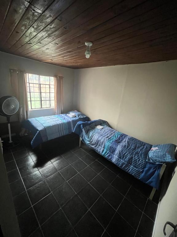 two beds in a room with a ceiling at Magnolia Departamento/Apartment in Barrio Esteban Echeverría