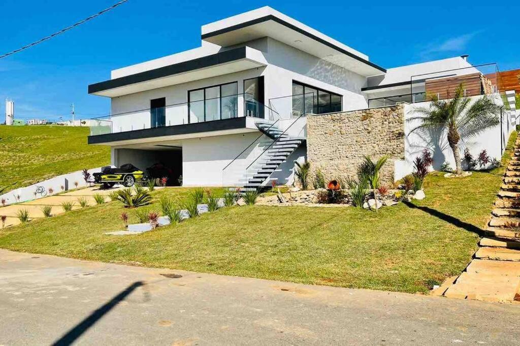 uma grande casa branca com um relvado em frente em Casa Alto Padrão Represa de Itupararanga Ibíuna em Sorocaba