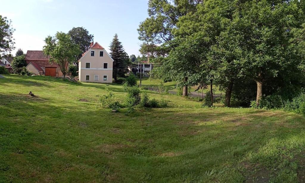 een huis bovenop een grasheuvel met bomen bij Ubytování Habartice in Habartice