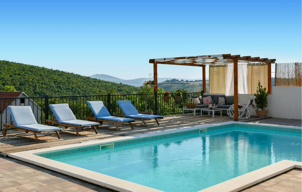 einen Pool mit Stühlen und einer Pergola in der Unterkunft Stunning Home In Ruda With House A Panoramic View in Ruda